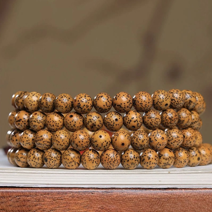 Close-up side view of authentic bodhi seed bead strand showing natural spotted tan texture and uniform bead arrangement
