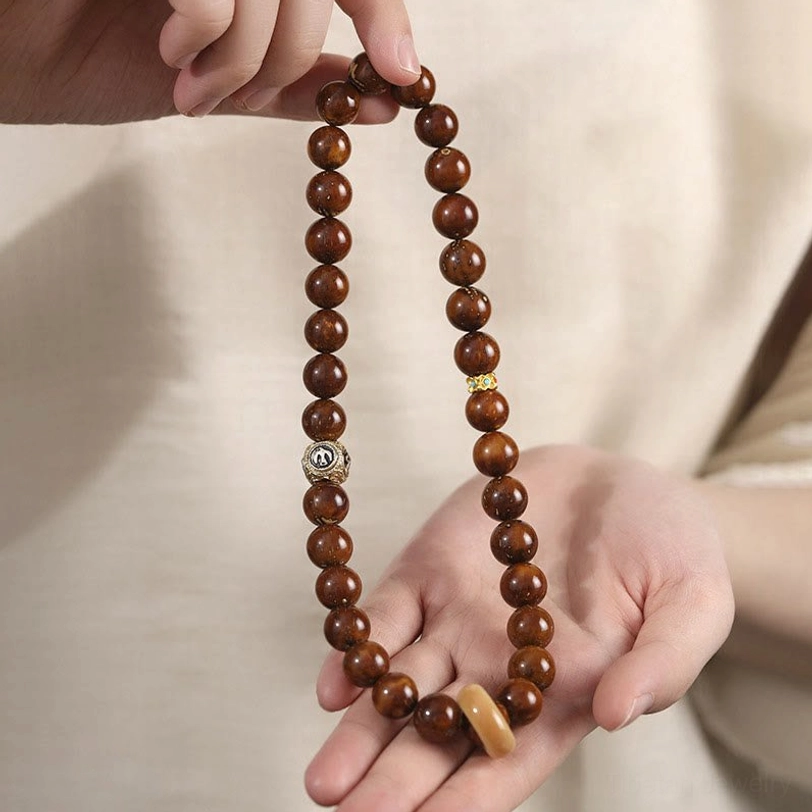 Tibetan Bodhi seed prayer bead bracelet worn on hand showing real-life lifestyle view with silver charm