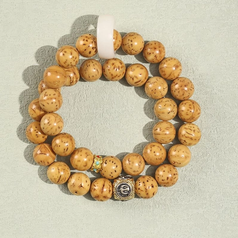 Light tan spotted natural Bodhi seed double wrap bracelet with silver charm and white spacer ring