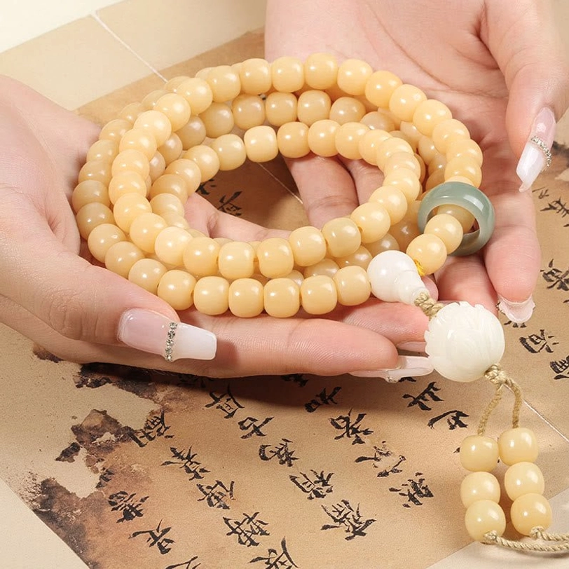 Overhead view of complete bodhi seed bracelet with green jade ring and white lotus tassel