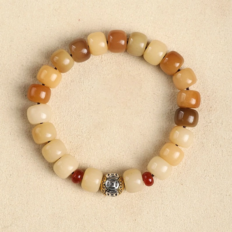 Bodhi seed copper coin bracelet, overhead flat lay product shot with warm brown and cream barrel beads and branded metal charm detail
