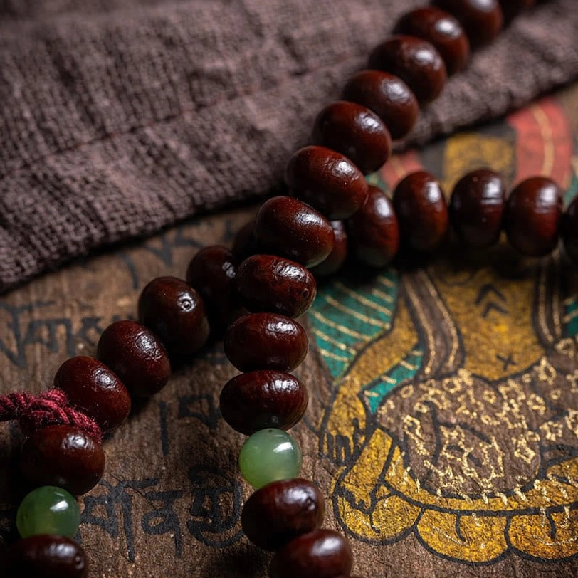 Close-up detail of purple bodhi seeds and green hetian jade beads in tibetan mala strand