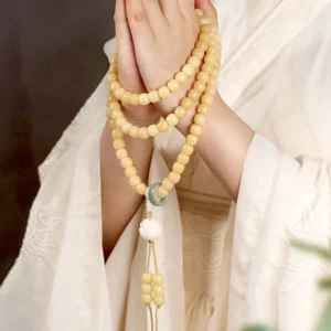 Tibetan bodhi seed lotus dzi bead bracelet worn on wrist with lotus tassel pendant detail