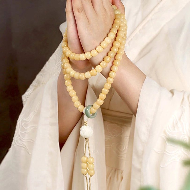 Tibetan bodhi seed lotus dzi bead bracelet worn on wrist with lotus tassel pendant detail