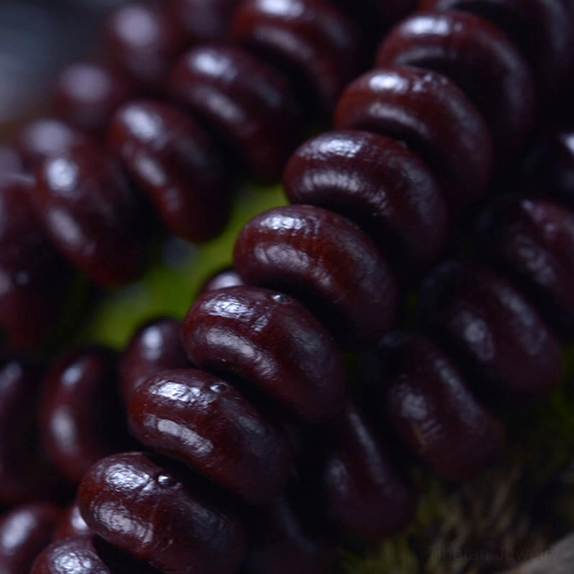 Extreme macro photography of Purple Bodhi Seed beads showing rich dark red texture and natural surface marks