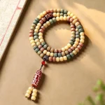 108 bodhi seed mala beads with tibetan dzi pendant displayed in overhead flat lay on warm wooden surface with meditation decor