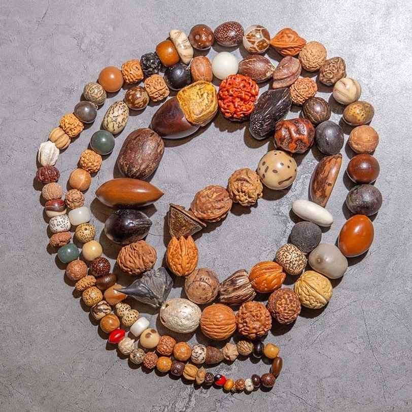 108 Bodhi seed mala beads bracelet flat lay, natural brown earthy tones coiled circular design for meditation and prayer