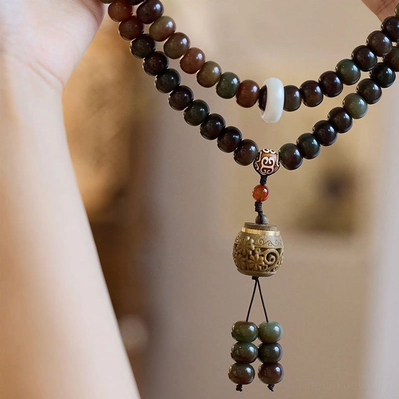 Tibetan bodhi seed mala bracelet worn on forearm showing white spacer bead and protective Dzi stone accent