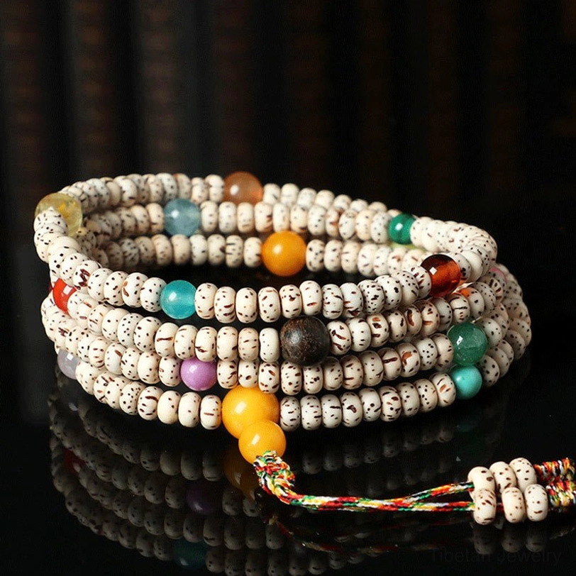 Stacked Tibetan bodhi seed mala bracelets with amber and gemstones layered display