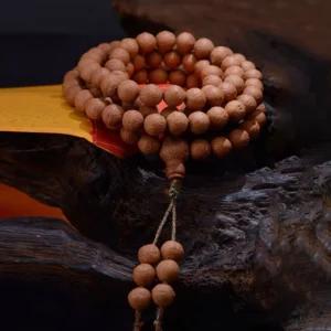 Close-up overhead view of Nepal Bodhi seed prayer beads showing deep brown seeds with natural markings and hanging tassel
