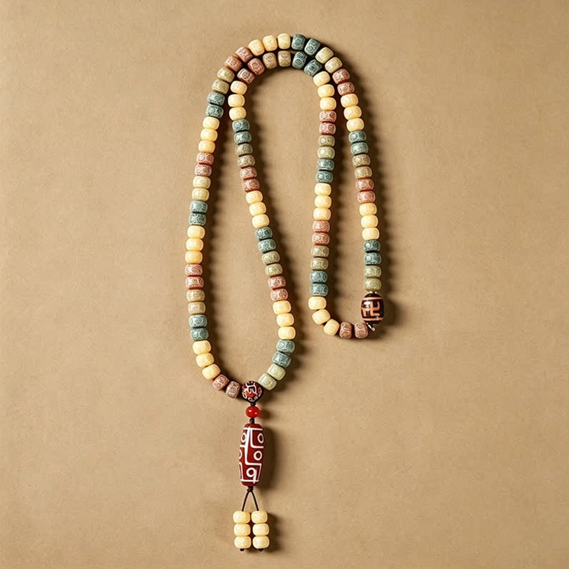 108 bodhi seed mala prayer beads with dzi bead pendant hanging overhead on warm beige background with tassel