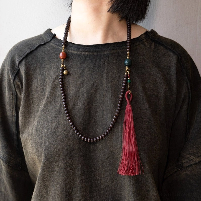 Purple bodhi seed mala worn as long necklace on person showing versatile styling