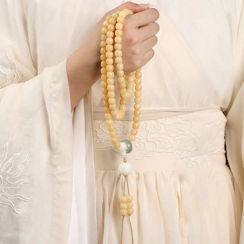 Long bodhi seed prayer mala bracelet with yellow beads and matching tassel pendant detail