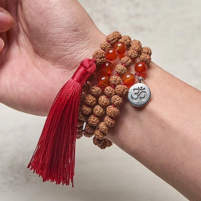 Bodhi seed mala prayer beads worn on wrist with Om charm and red tassel