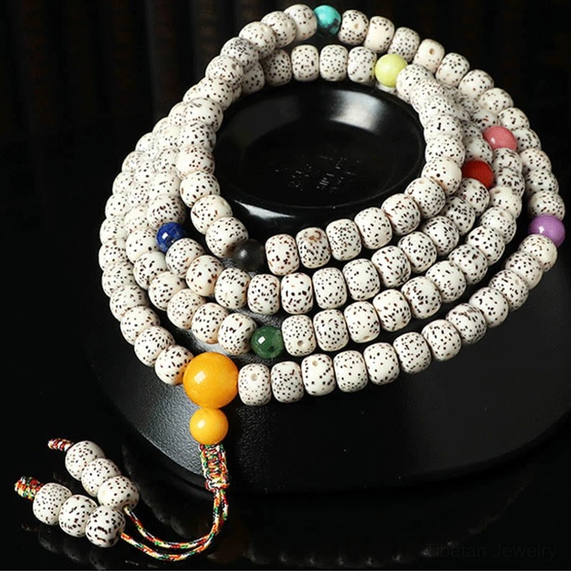 Handmade bodhi seed meditation bracelet with multicolor beads and tassel pendant on black ceramic base