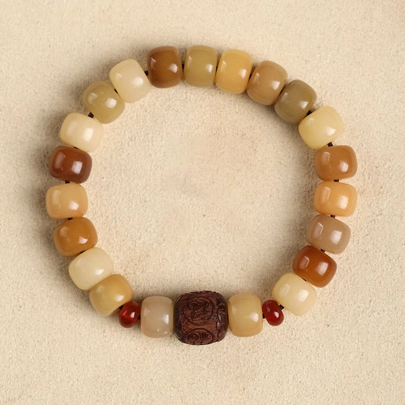 Bodhi seed Om Mani Padme Hum bracelet featuring wooden carved focal bead with warm brown and cream barrel beads