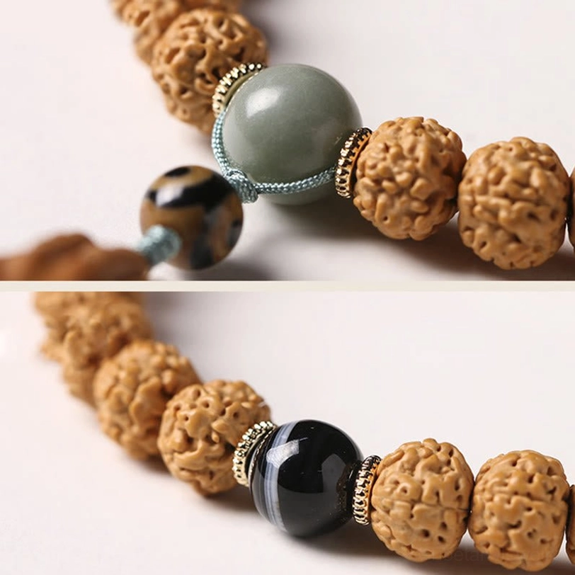 Bodhi seed prayer bracelet with Dzi bead and traditional Buddhist pendant on neutral surface