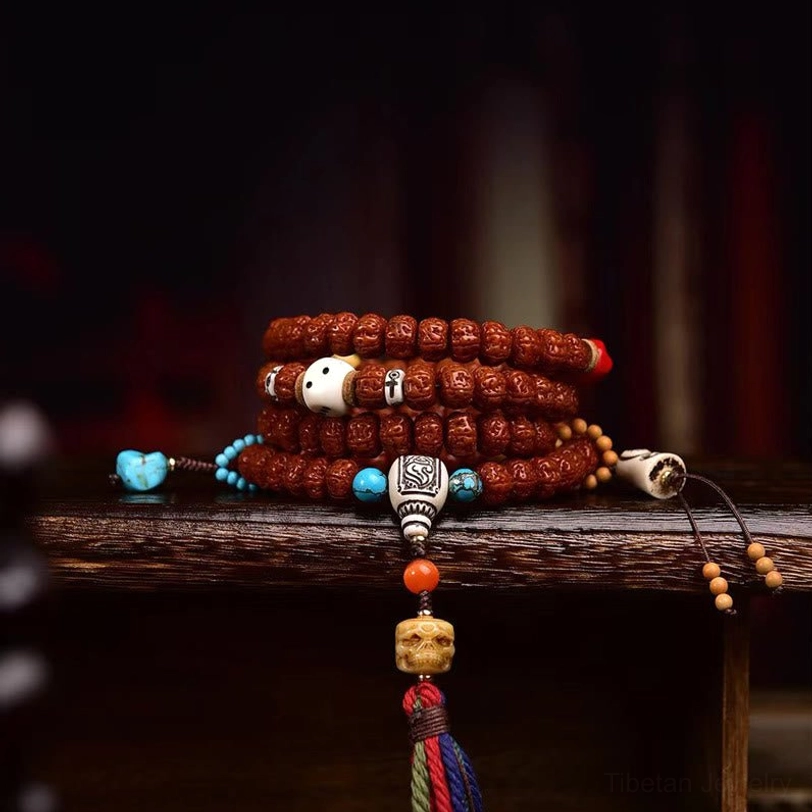 108 Bodhi seed mala bracelet bundled display showing turquoise accents, silver carved guru bead, and reddish prayer beads three-quarter view