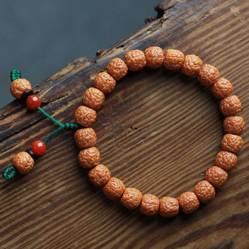Complete circular rudraksha bodhi seed bracelet with green tassels and red agate accents