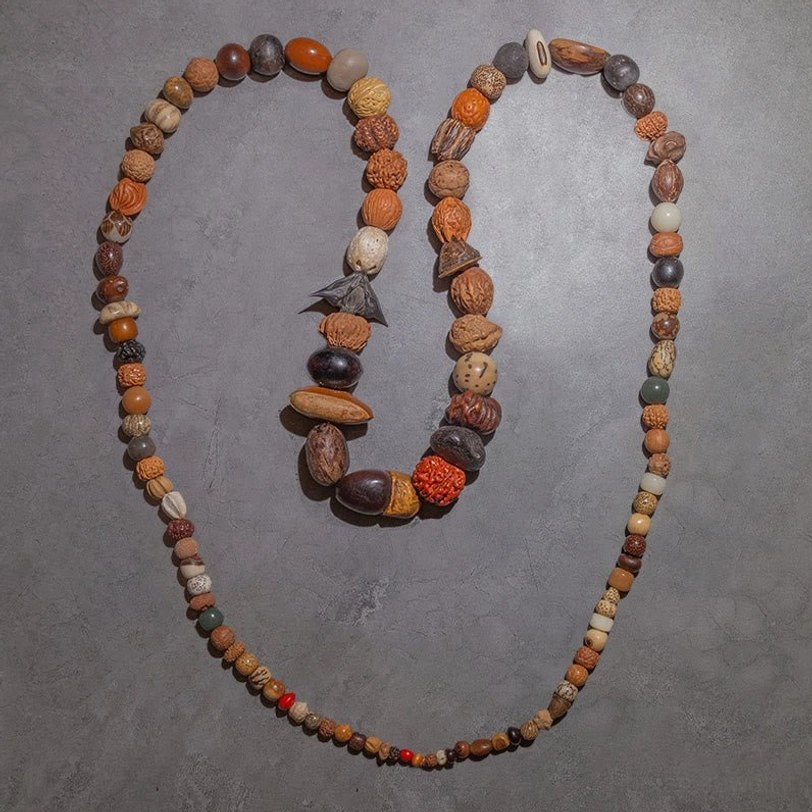 Single-wrap Bodhi seed mala bracelet with lotus wooden tassel pendant and white-red accent beads, wearable meditation tool