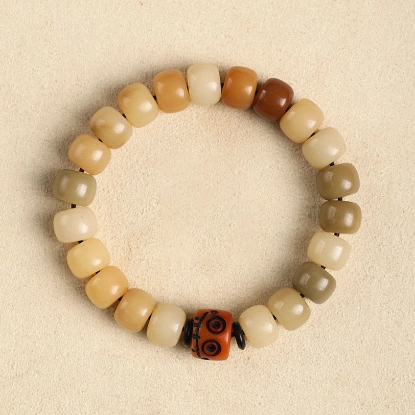 Bodhi seed and yak bone Tibetan protection bracelet with carved metal charm, combining natural materials from Himalayan tradition