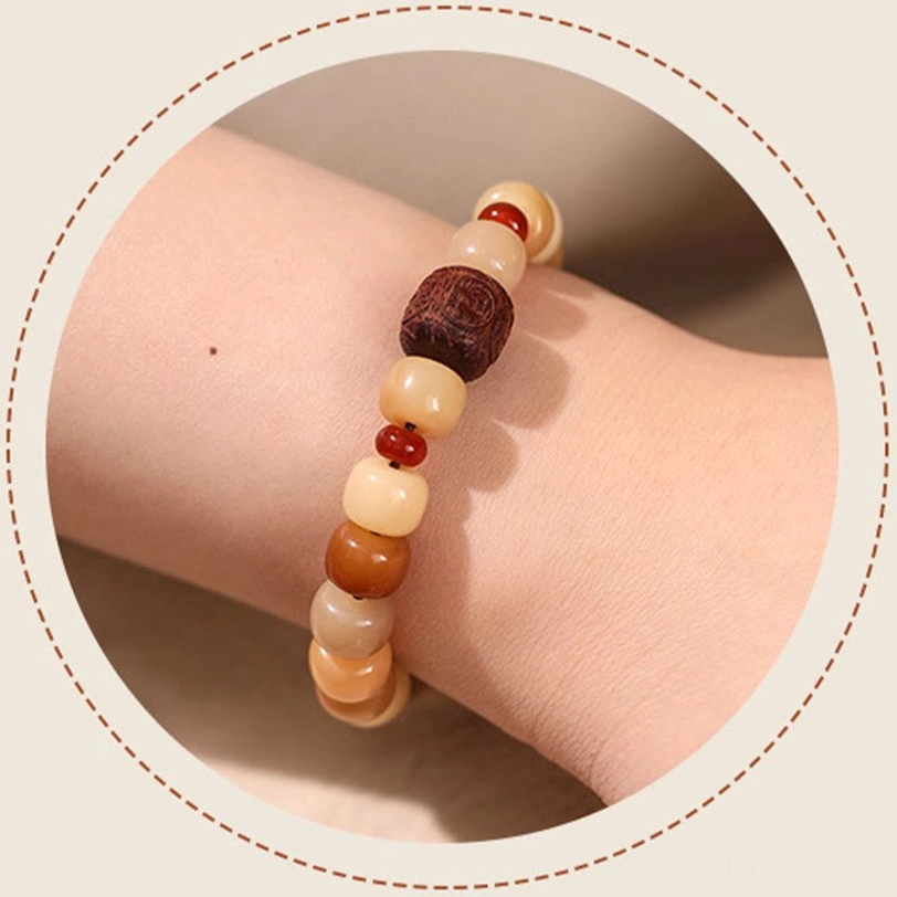 Bodhi seed wisdom bracelet worn on wrist, close-up personal wear view showcasing warm earth tone natural beads and wooden carved charm