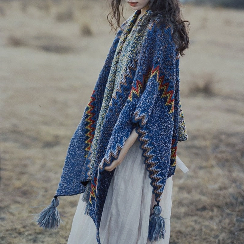 Three-quarter side view of bohemian knit poncho featuring ethnic pattern, loose sleeve style and side tassels