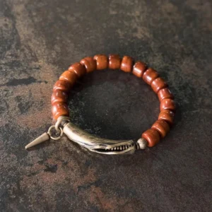 Handcrafted bone beads with curved bronze clasp detail, top angle view on weathered background