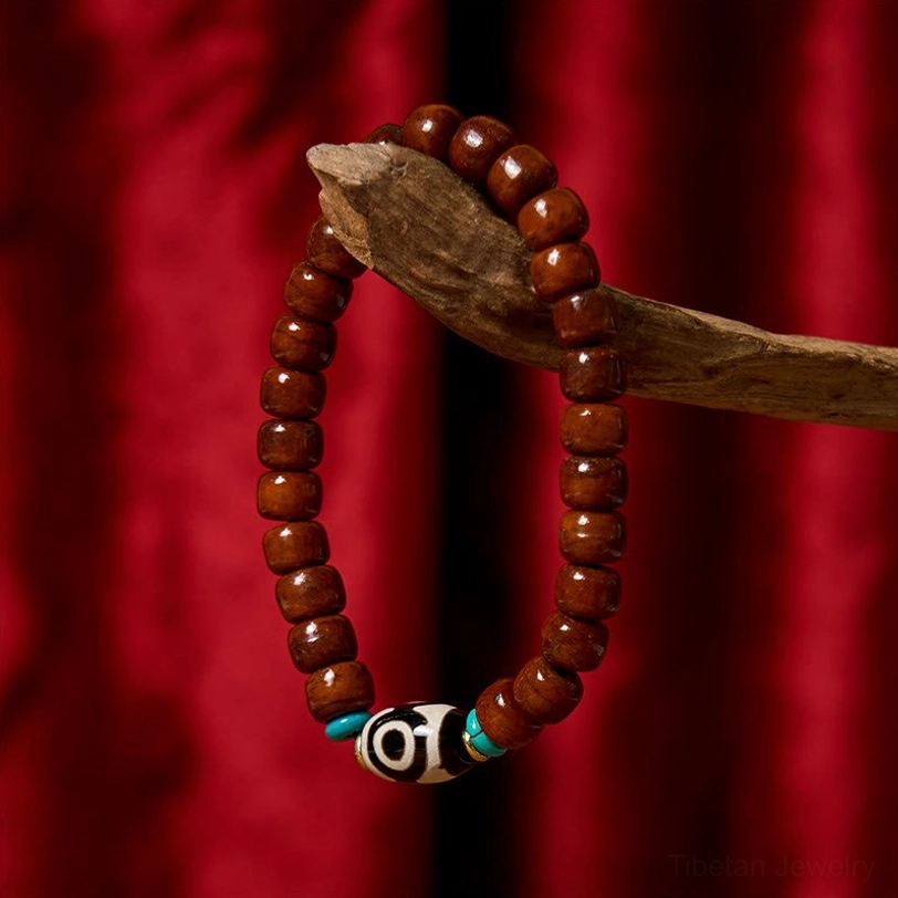 Single-strand Tibetan bone bead bracelet with three-eye Dzi and turquoise spacers on red velvet