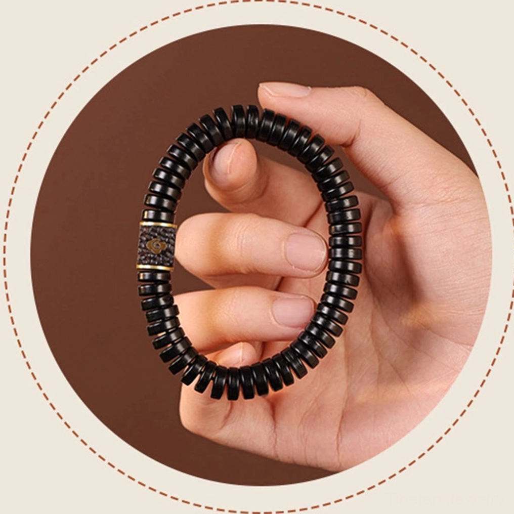 Hand-held coconut shell bracelet display showing flexibility and craftsmanship detail