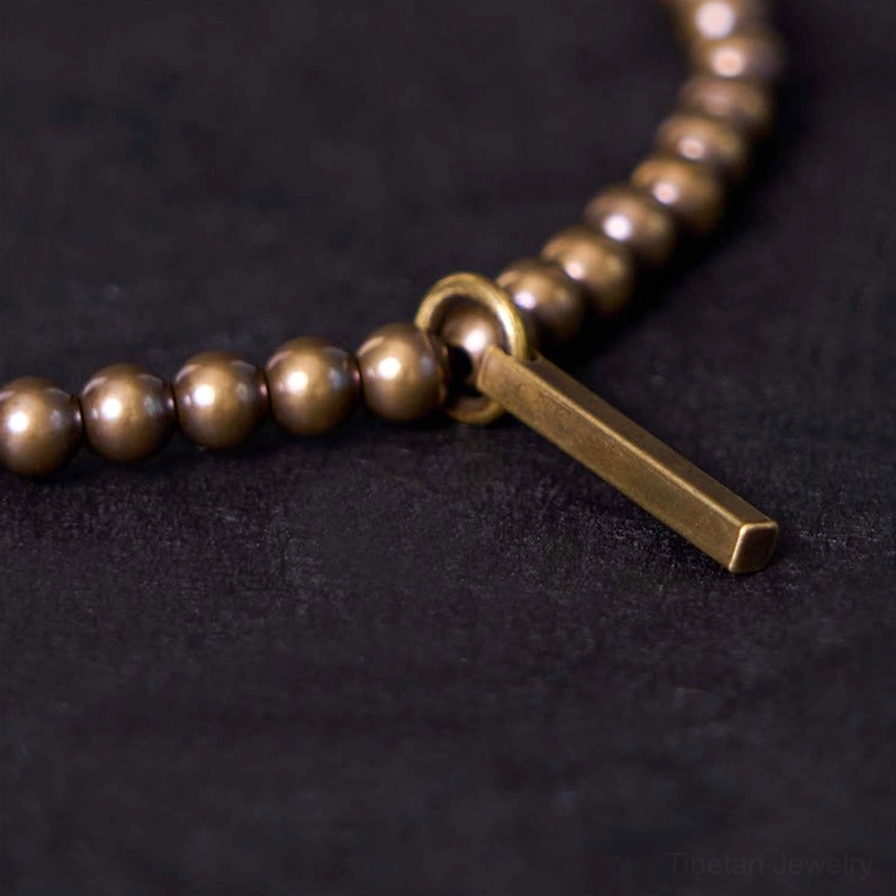 Macro detail shot of matte metal beads and brass bar charm components