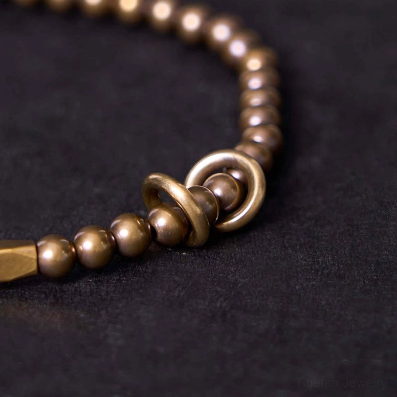 Macro close-up of double-ring metal clasp with polished bronze finish on brass bracelet