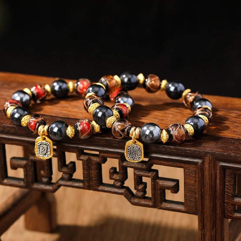 Earthy tone brown and red mixed liuli glass wealth bracelets with gold spacers on carved Chinese wooden shelf