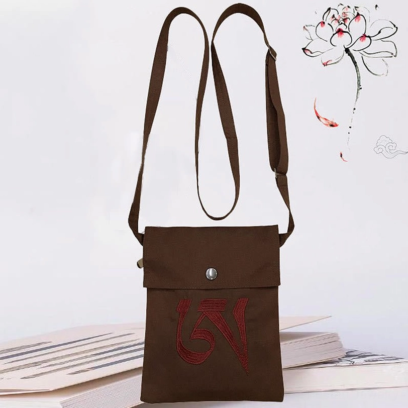 Dark brown Tibetan OM mantra crossbody bag with red embroidered mantra, adjustable brown canvas strap, snap flap closure