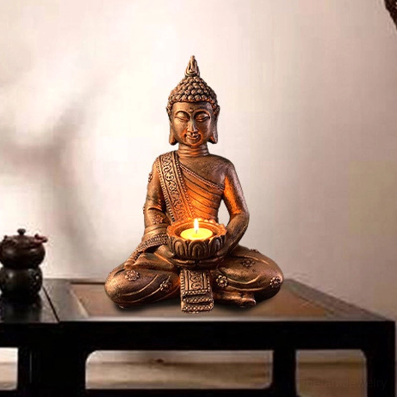 Tibetan Buddha candleholder displayed on dark wood side table with warm bronze tone and lit tea light, traditional Asian home decor