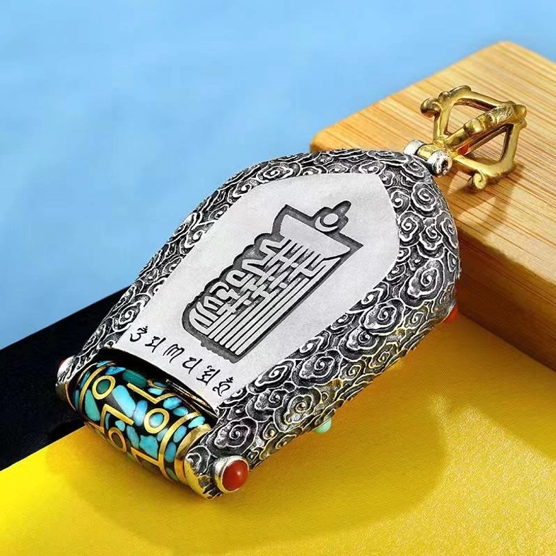 Tibetan Buddha pendant reverse side with Sanskrit engravings and vajra clasp detail