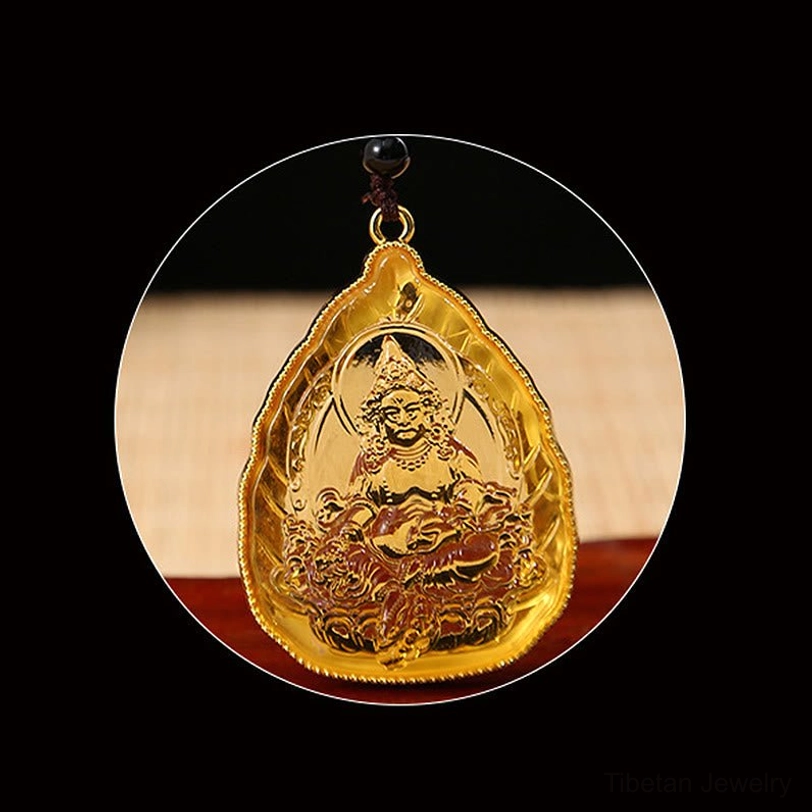 Magnified circular view of golden Buddha seated engraving on leaf-shaped crystal with gold trim