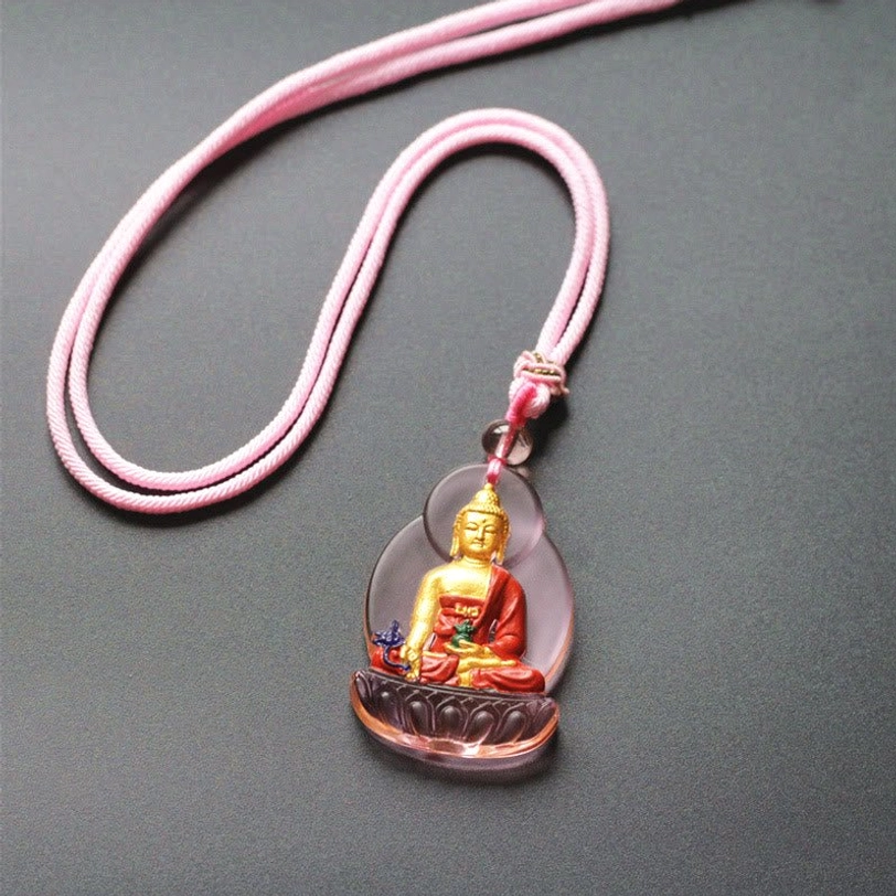 Tibetan Buddha pendant necklace with pale pink Liuli glass frame, red and gilt Buddha figure, and light pink braided rope