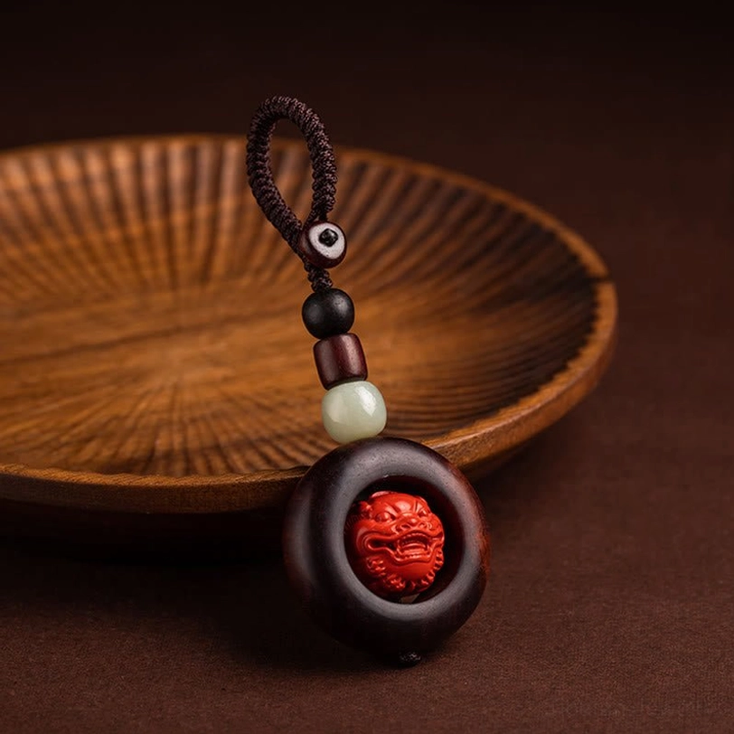 Close-up of hand-carved cinnabar bead featuring Om Mani Padme Hum Sanskrit script and lotus flower patterns