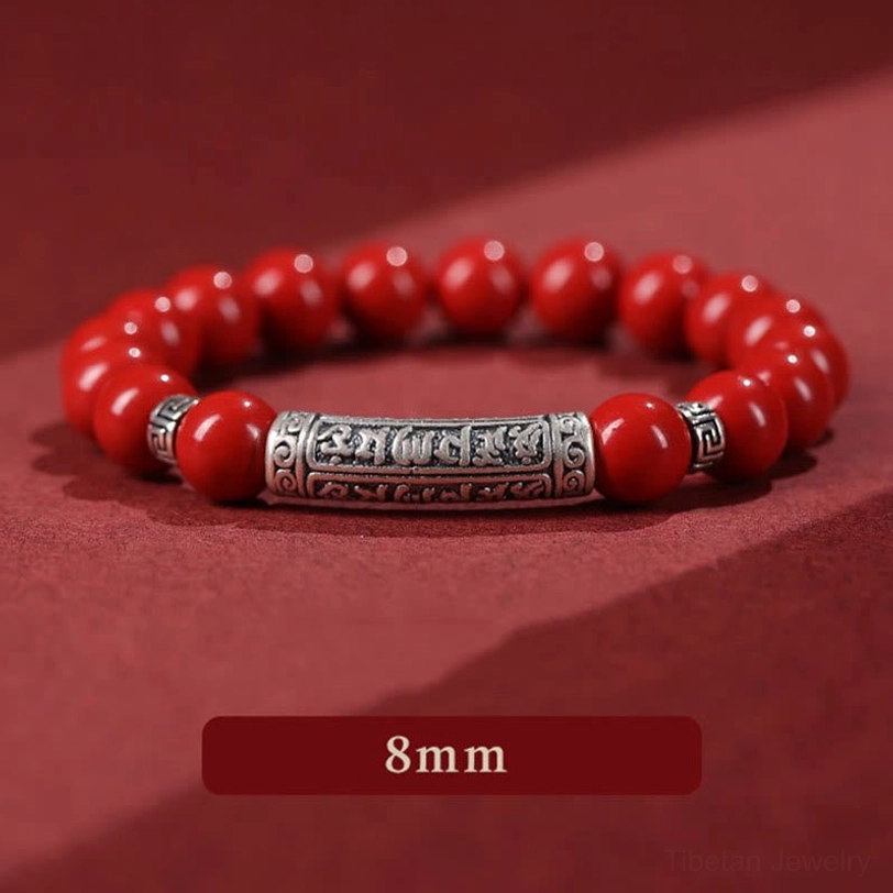 8mm cinnabar beads detail macro shot displaying larger polished red spheres with hand-engraved silver accent tube