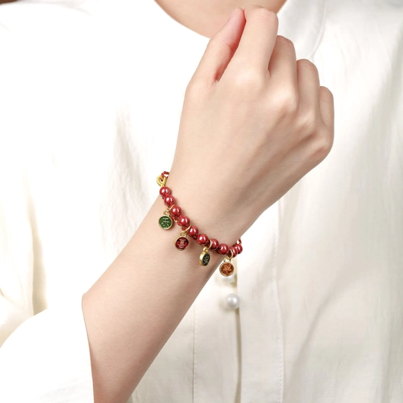 Wearable cinnabar red string bracelet fitted on wrist against white clothing, displaying natural cinnabar beads and adjustable fit