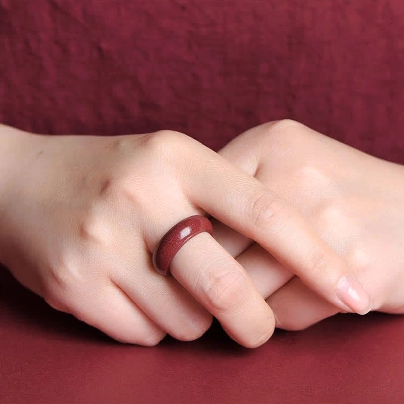 Cinnabar om mani padme hum blessing ring worn on woman's finger showing natural hand fit and deep red color