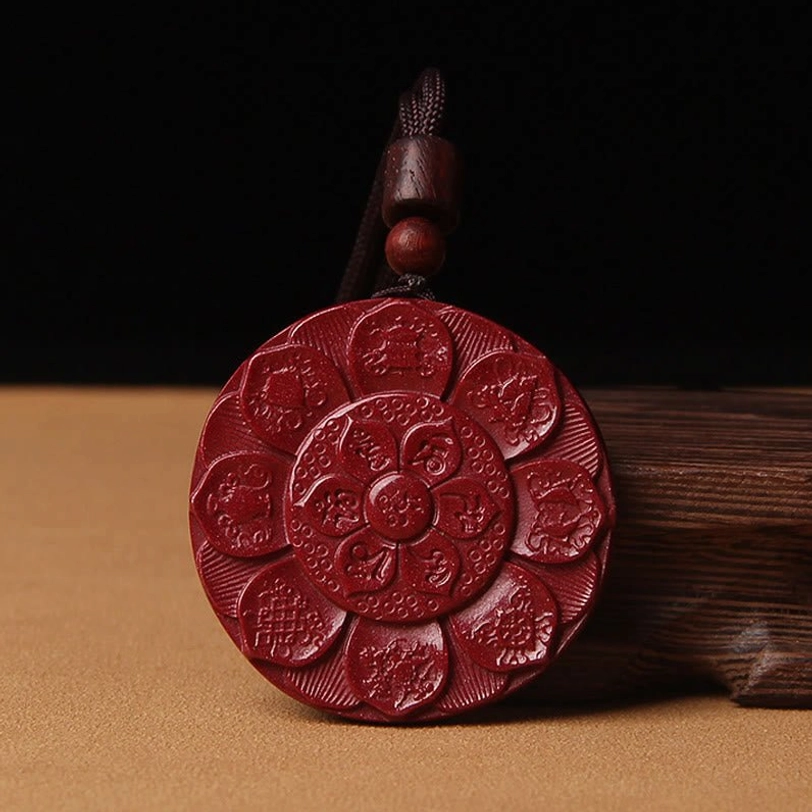 Front view of hand-carved cinnabar lotus pendant with sacred Buddhist motifs and deep red color, Om Mani Padme Hum design