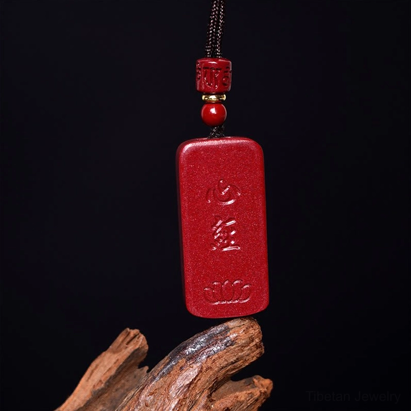 Cinnabar Lotus Heart Sutra pendant necklace showing front face with deep-carved Sanskrit text on red stone