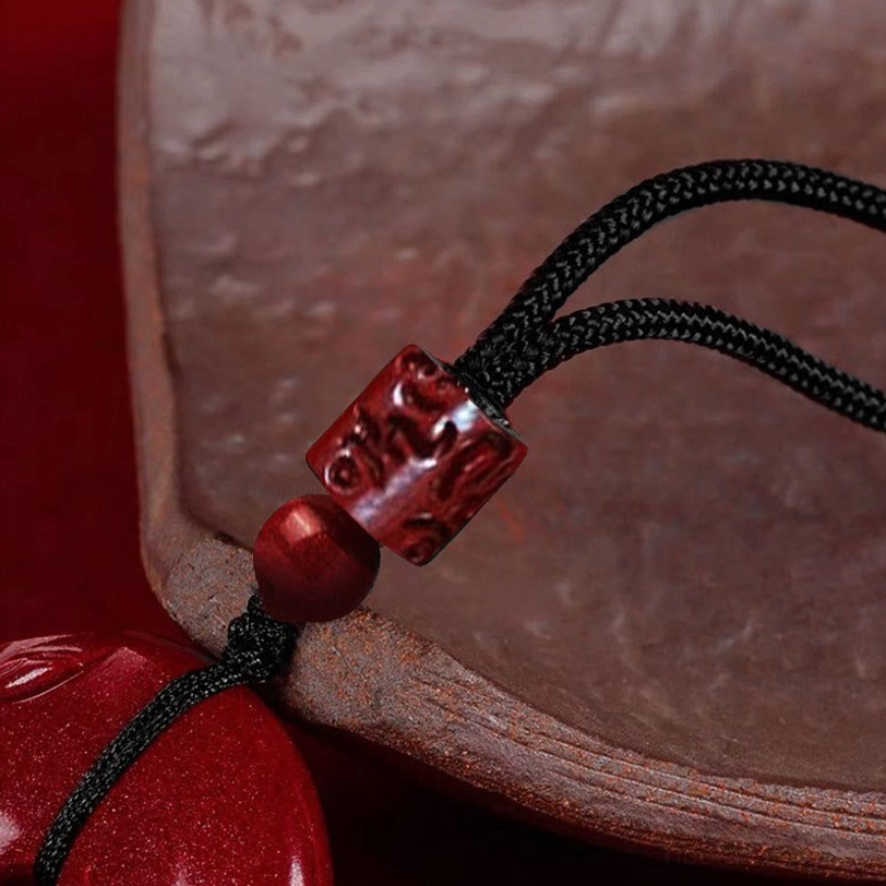 Cinnabar necklace hardware assembly detail showing hand-braided black cord with cinnabar beads and metal spacer components