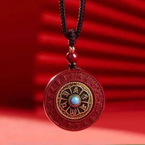 Tibetan Cinnabar Necklace with Rotating Om Mani Padme Hum Pendant - Front View on Brown Cotton Cord