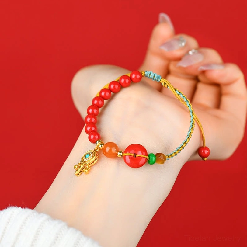 Close-up detail of cinnabar peace buckle blessing bracelet showing braided chain texture and decorative peace buckle pendant