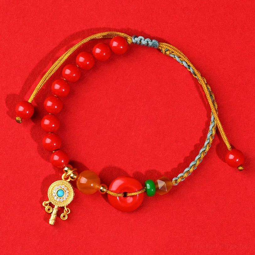 Complete cinnabar peace buckle blessing bracelet top-down view with full display of dangling red bead ends on red background