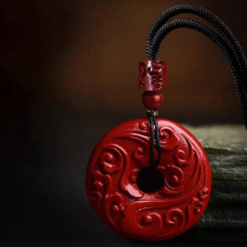 Cinnabar peace buckle pendant necklace showing carved cylindrical bead and round spacer on adjustable cord, side angle close-up