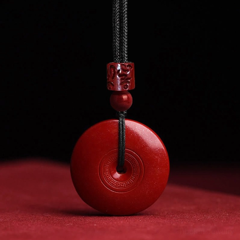 Plain cinnabar peace buckle pendant with concentric circle engravings on smooth red surface, front close-up photography
